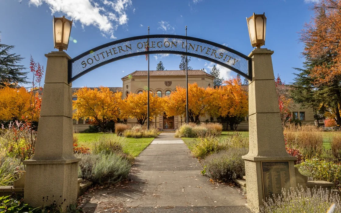 The Southern Oregon University archway, autumn trees behind it